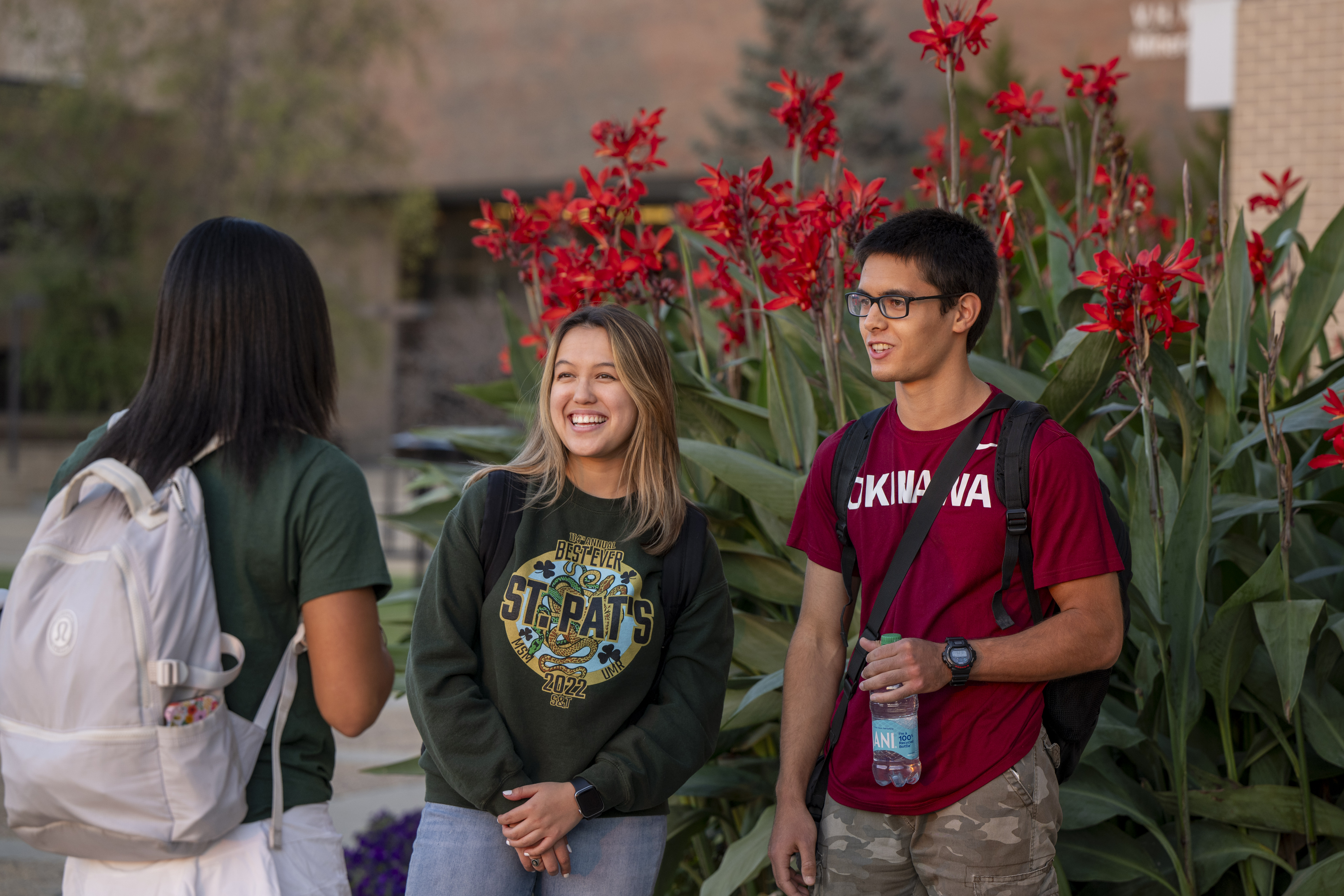 Three students at Missouri S&T Visit in front of beautiful flowers